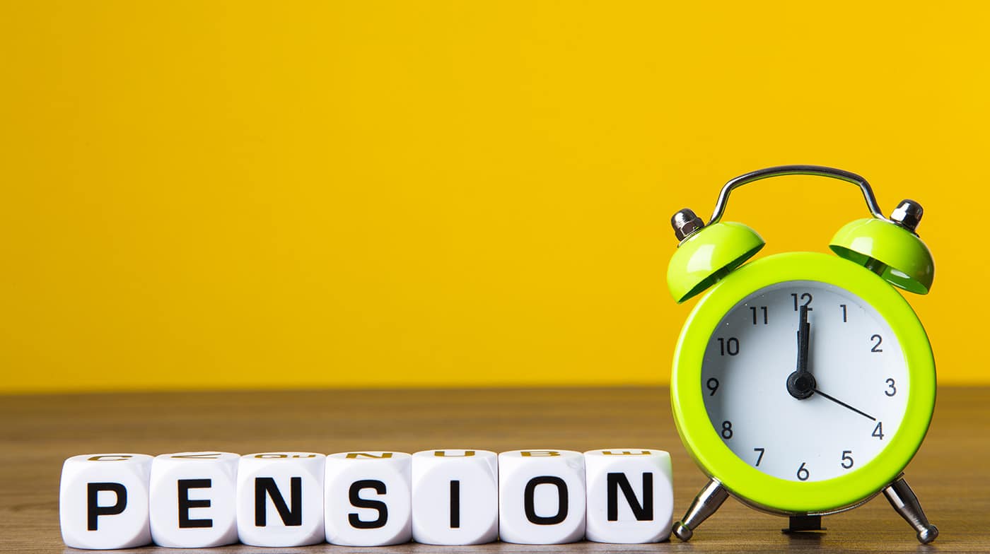 Inscription Pension and alarm clock on yellow background