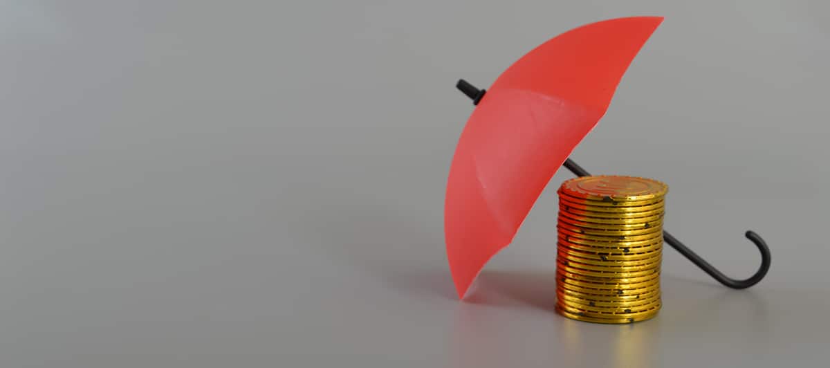 Red umbrella and the stack of coins. Keeping money safe. savings protection, Investment and capital insurance concept.